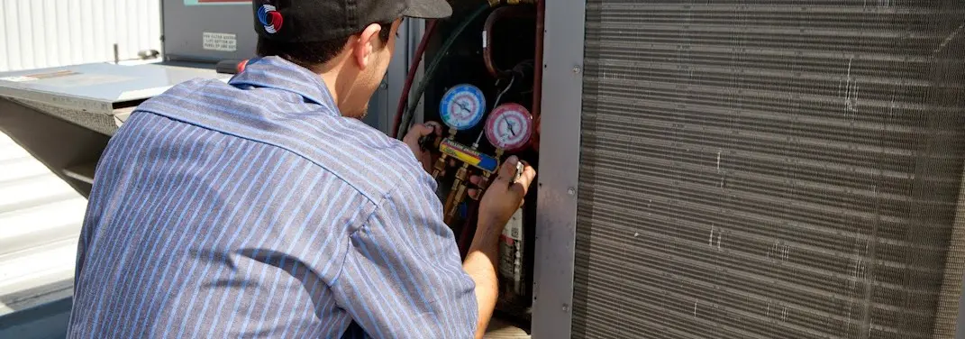 HVAC technician servicing a condenser unit in Americus